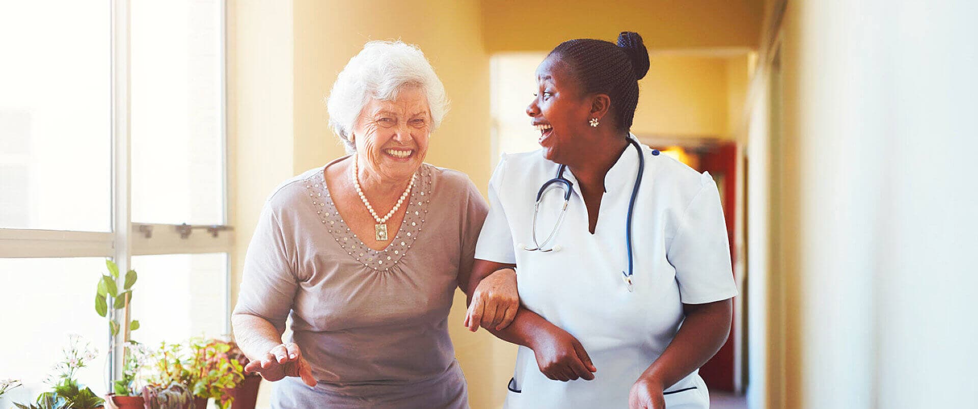 senior woman and nurse smiling