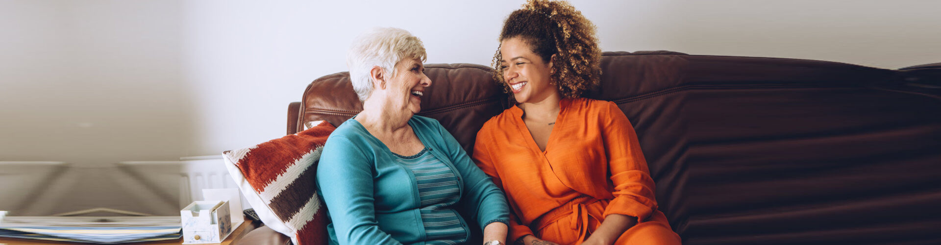 senior woman and caregiver smiling