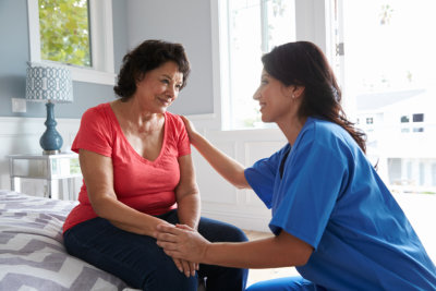 Nurse taking care of suffering senior patient at home